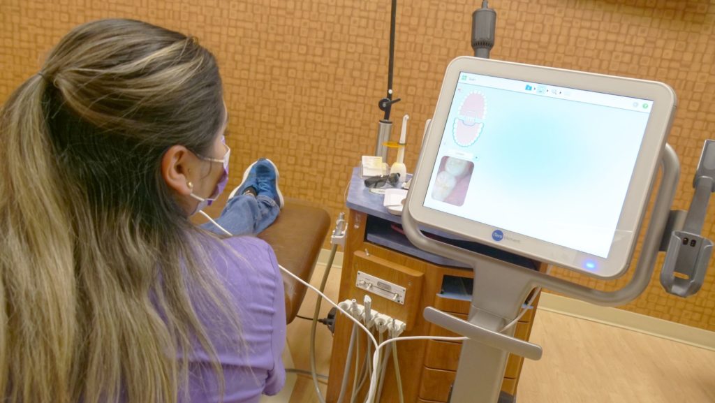 Assistant scanning a patient's teeth